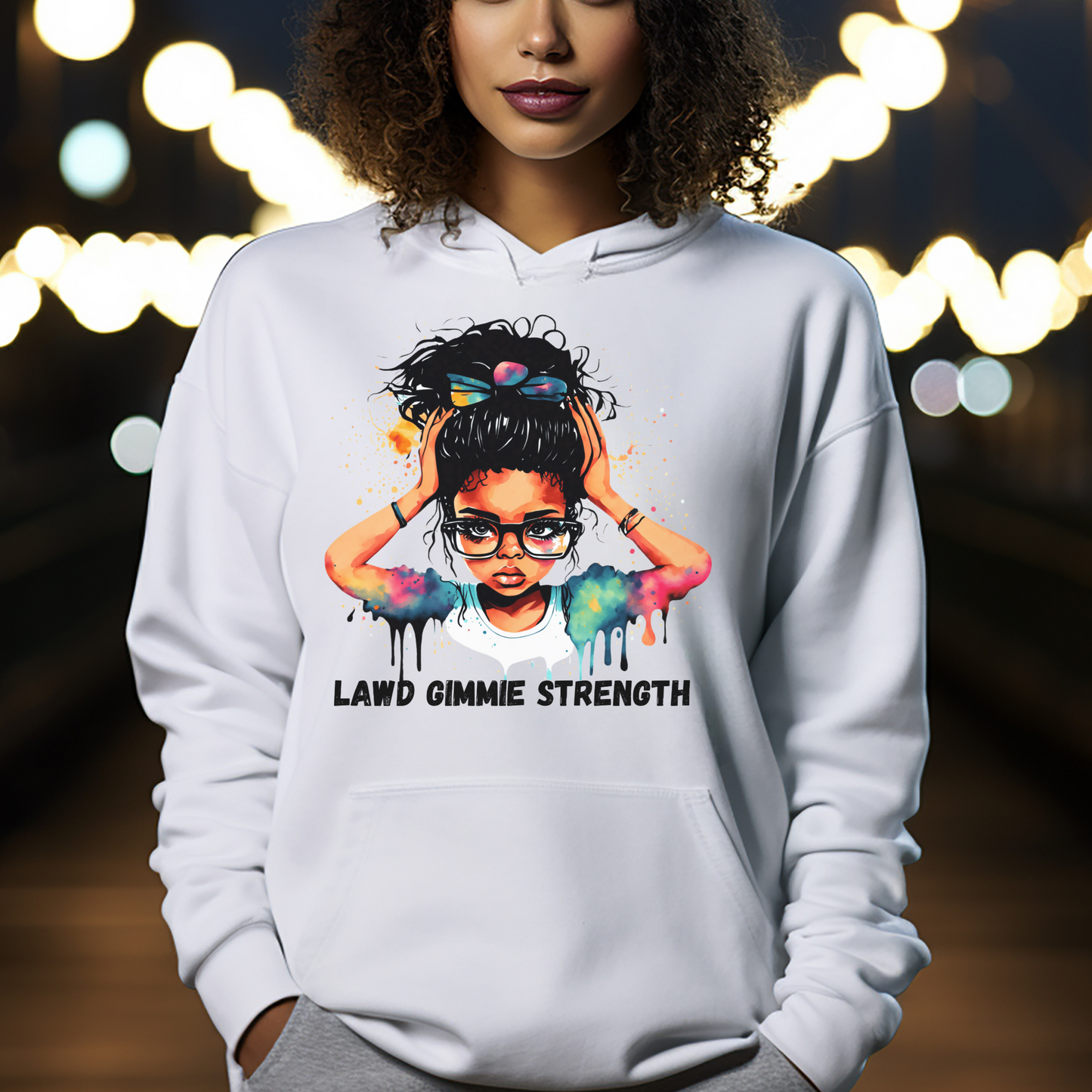 Woman wearing a white hoodie with a graphic design and text, standing against a blurred lights background.