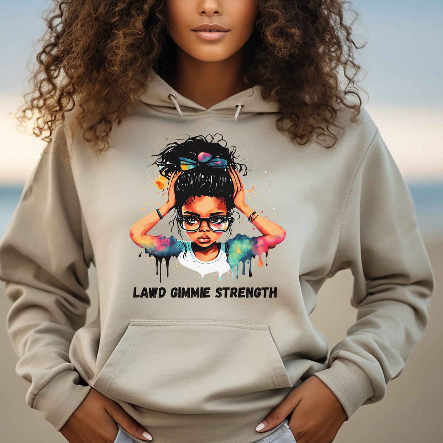 Woman wearing a hoodie with a colorful graphic and text on a beach