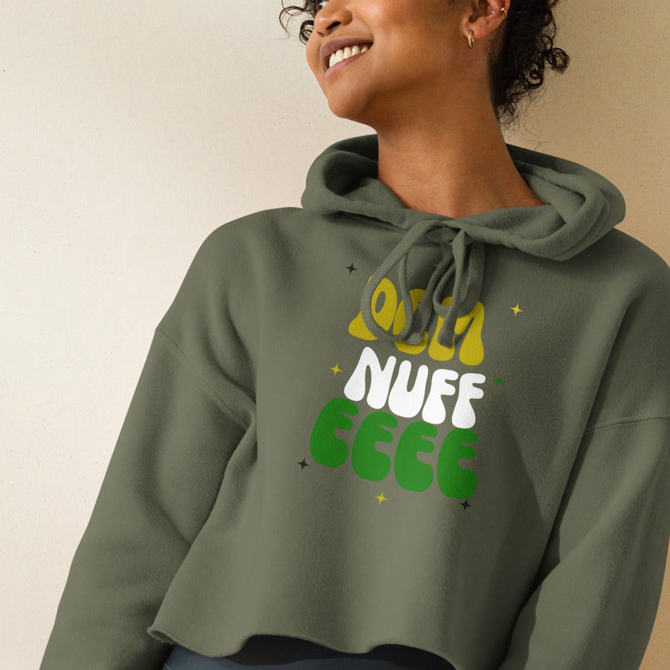 Person wearing a green hoodie with text and dark shorts on a plain background